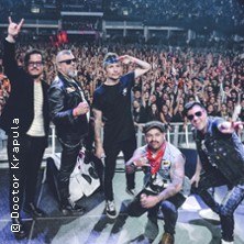 Die Band Doctor Krapula posiert vor einer großen Menschenmenge auf einem Konzert. Die Mitglieder tragen lässige Kleidung und wirken energiegeladen., © links im Bild Die Band Doctor Krapula posiert vor einer großen Menschenmenge auf einem Konzert. Die Mitglieder tragen lässige Kleidung und wirken energiegeladen., © links im Bild