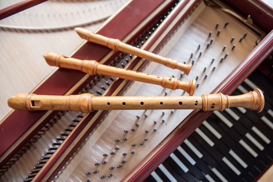 Drei hölzerne Blockflöten liegen auf den Saiten eines geöffneten Cembalos. Die Flöten sind parallel angeordnet., © Jens Volle