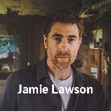 Ein Mann mit Bart in einem rustikalen Raum, umgeben von Kunstwerken. Der Name Jamie Lawson ist eingeblendet., © links im Bild Ein Mann mit Bart in einem rustikalen Raum, umgeben von Kunstwerken. Der Name Jamie Lawson ist eingeblendet., © links im Bild