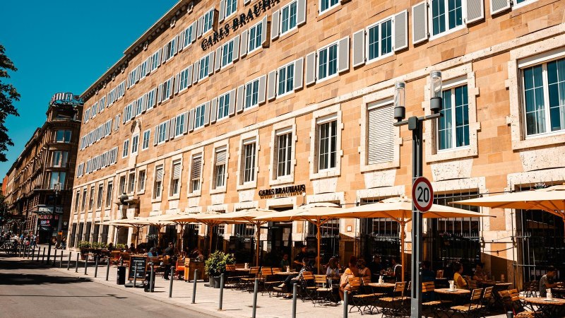 Carls Brauhaus mit gelbem Gebäude, vielen Fenstern und Außenterrasse mit Sonnenschirmen und Sitzplätzen. Menschen genießen das sonnige Wetter., © Stuttgart Marketing GmbH, Sarah Schmid Carls Brauhaus mit gelbem Gebäude, vielen Fenstern und Außenterrasse mit Sonnenschirmen und Sitzplätzen. Menschen genießen das sonnige Wetter., © Stuttgart Marketing GmbH, Sarah Schmid