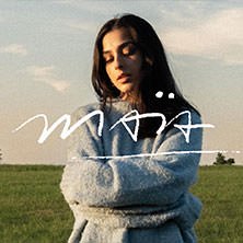 Frau in grauem Pullover steht mit verschränkten Armen auf einer Wiese. Der Himmel ist leicht bewölkt., © links im Bild Frau in grauem Pullover steht mit verschränkten Armen auf einer Wiese. Der Himmel ist leicht bewölkt., © links im Bild