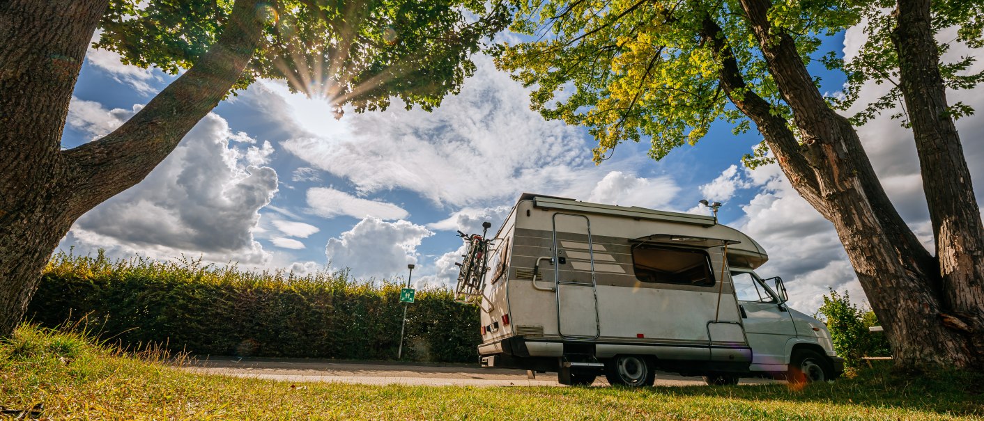 Ein Wohnmobil steht unter Bäumen auf einem Stellplatz. Die Sonne scheint durch das Blätterdach, der Himmel ist teils bewölkt., © Stuttgart-Marketing GmbH, Thomas Niedermüller Ein Wohnmobil steht unter Bäumen auf einem Stellplatz. Die Sonne scheint durch das Blätterdach, der Himmel ist teils bewölkt., © Stuttgart-Marketing GmbH, Thomas Niedermüller