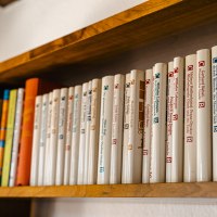 A wooden shelf with a row of books in white bindings, neatly lined up next to each other., © SMG Stuttgart Marketing GmbH - Sarah Schmid A wooden shelf with a row of books in white bindings, neatly lined up next to each other., © SMG Stuttgart Marketing GmbH - Sarah Schmid