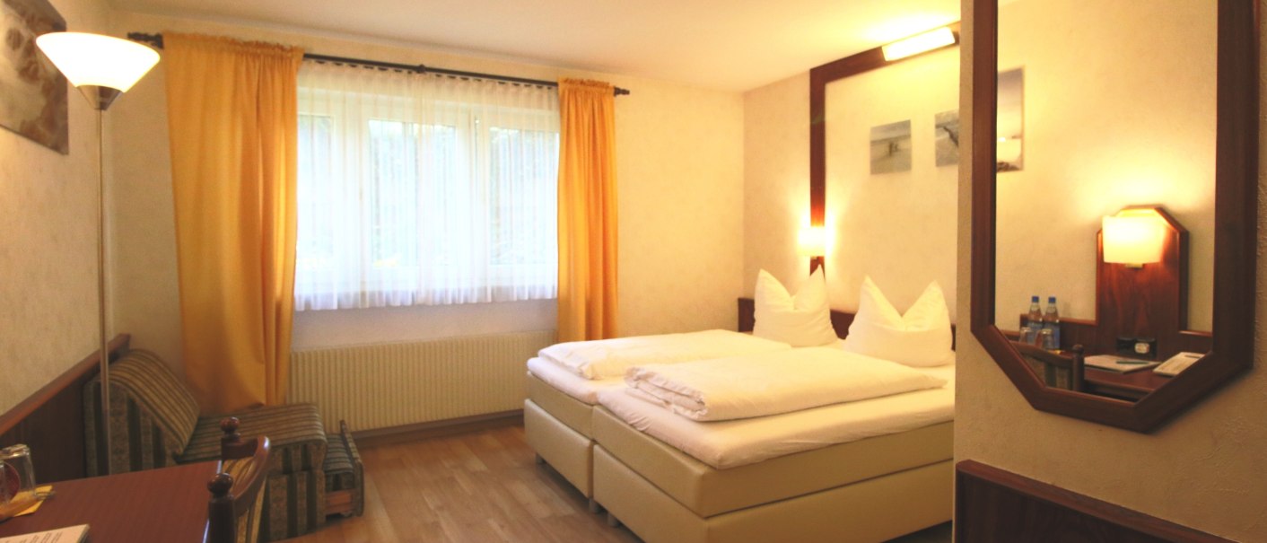 Comfortable double room with double bed, desk, armchair and large window with yellow curtains., © TOMAS Comfortable double room with double bed, desk, armchair and large window with yellow curtains., © TOMAS
