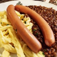 A plate of lentils, spaetzle and two sausages, served on a table with cutlery., &copy; TMBW, Susi Maier