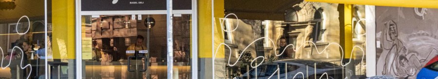 Shop window of the deli with yellow awnings. Above the door at the corner of the building it says "jomi Bagel Deli"., © Stuttgart-Marketing GmbH, Sarah Schmid Shop window of the deli with yellow awnings. Above the door at the corner of the building it says "jomi Bagel Deli"., © Stuttgart-Marketing GmbH, Sarah Schmid