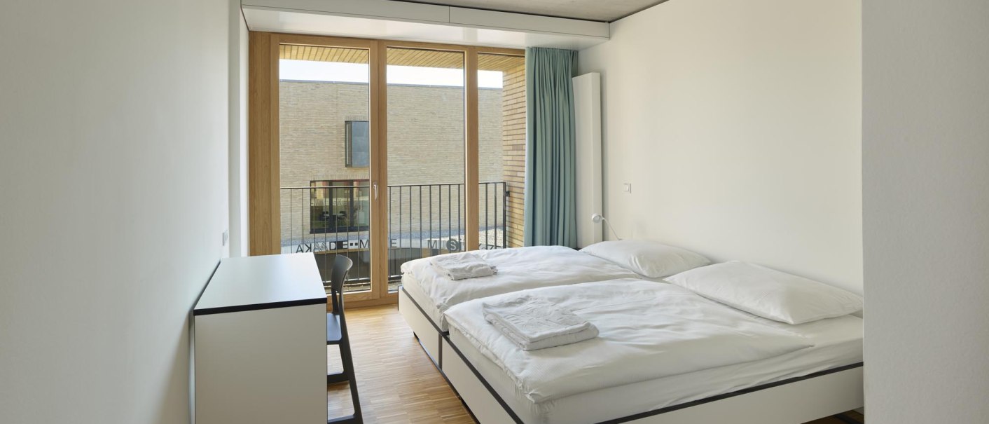 Modern double room with two beds, a desk, and a large window with curtains. Bright, minimalist decor., &copy; TOMAS