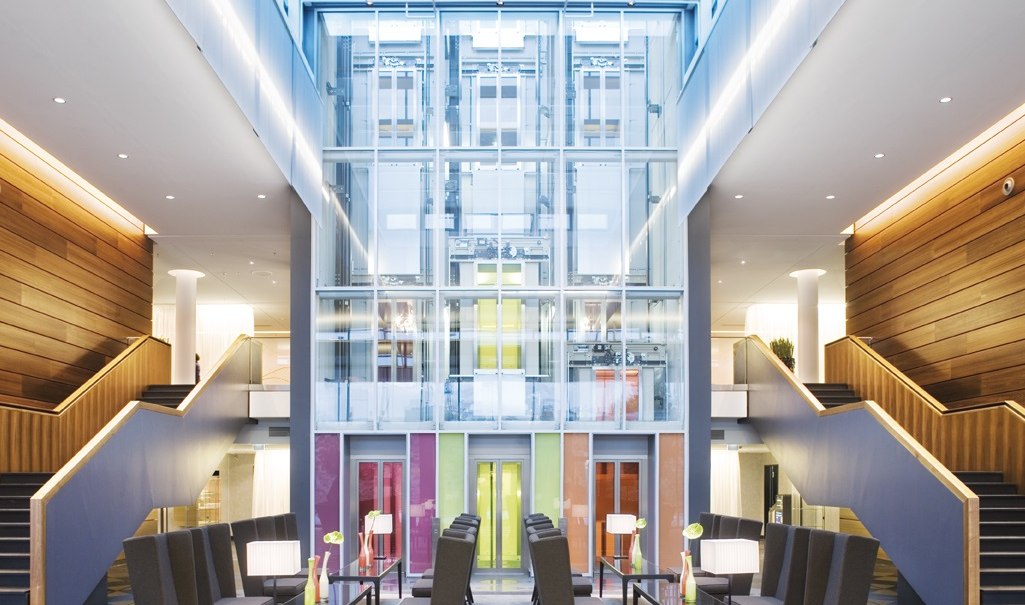 Moderne Lobby im Mövenpick Hotel Stuttgart Airport mit hohen Decken, Glaswänden, symmetrischen Treppen und eleganten Sitzbereichen., © Mövenpick Hotel Stuttgart Airport Moderne Lobby im Mövenpick Hotel Stuttgart Airport mit hohen Decken, Glaswänden, symmetrischen Treppen und eleganten Sitzbereichen., © Mövenpick Hotel Stuttgart Airport