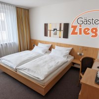 Helles Hotelzimmer mit Doppelbett, Schreibtisch, Fernseher und Wasserkocher im Gästehaus Ziegler. Moderne Dekoration und große Fenster mit Vorhängen., © Gästehaus Ziegler Helles Hotelzimmer mit Doppelbett, Schreibtisch, Fernseher und Wasserkocher im Gästehaus Ziegler. Moderne Dekoration und große Fenster mit Vorhängen., © Gästehaus Ziegler