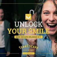Woman cheering with clenched fists, other people celebrating in the background. Text: "Unlock Your Smile" and "TeamEscape"., © TeamEscape Stuttgart Woman cheering with clenched fists, other people celebrating in the background. Text: "Unlock Your Smile" and "TeamEscape"., © TeamEscape Stuttgart