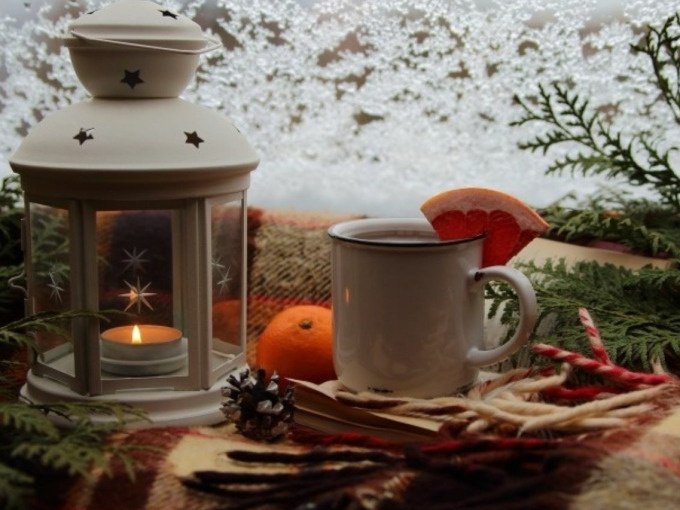 Winterliche Szene mit einer weißen Laterne, einer Tasse Glühwein mit Orangenscheibe, einer Orange und Tannenzweigen auf einer Decke., © Cool-Tours StattReisen Winterliche Szene mit einer weißen Laterne, einer Tasse Glühwein mit Orangenscheibe, einer Orange und Tannenzweigen auf einer Decke., © Cool-Tours StattReisen