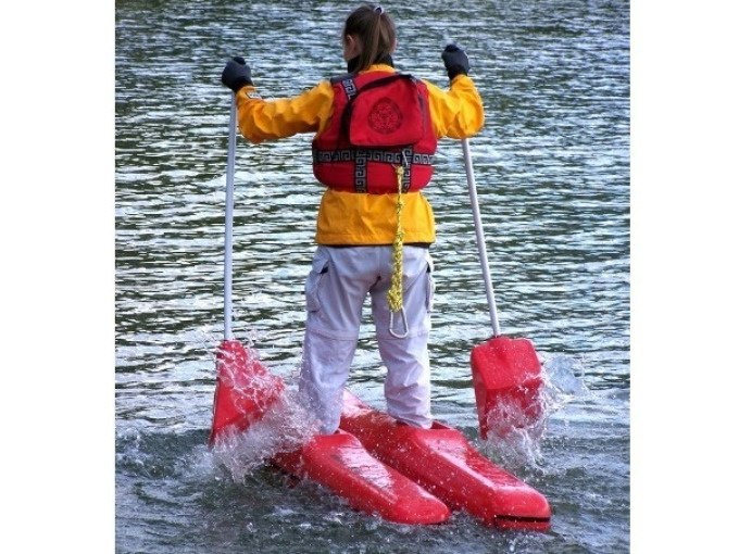 Person in yellow jacket and red vest stands on floating equipment in the water and holds two paddles., &copy; Cool-Tours StattReisen