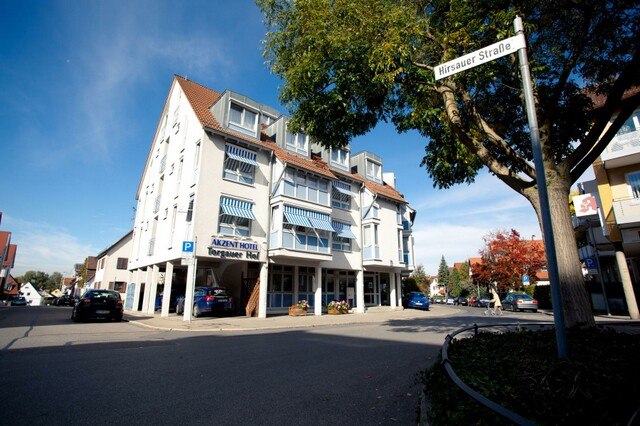 Das AKZENT Hotel Torgauer Hof an einer Straßenecke mit blauen Markisen und einem Baum im Vordergrund., © AKZENT Hotel Torgauer Hof Das AKZENT Hotel Torgauer Hof an einer Straßenecke mit blauen Markisen und einem Baum im Vordergrund., © AKZENT Hotel Torgauer Hof