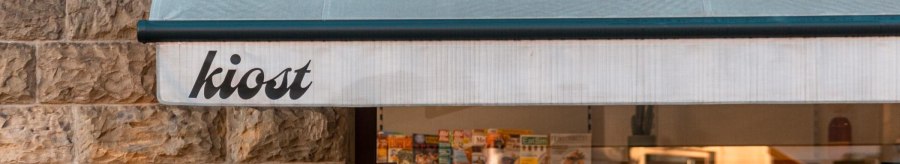 Ein Kiosk mit der Aufschrift 'kiost' zeigt Zeitschriften im Schaufenster. Die Steinwand und das Licht schaffen eine gemütliche Atmosphäre., © Stuttgart-Marketing GmbH, Sarah Schmid Ein Kiosk mit der Aufschrift 'kiost' zeigt Zeitschriften im Schaufenster. Die Steinwand und das Licht schaffen eine gemütliche Atmosphäre., © Stuttgart-Marketing GmbH, Sarah Schmid