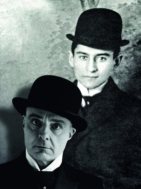 Ein Mann mit Melone und ernstem Blick steht vor einem alten Foto eines anderen Mannes mit Melone. Beide tragen Anzüge., © Renitenztheater Stuttgart e.V. Ein Mann mit Melone und ernstem Blick steht vor einem alten Foto eines anderen Mannes mit Melone. Beide tragen Anzüge., © Renitenztheater Stuttgart e.V.