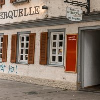 Das Restaurant Tauberquelle in Stuttgart zeigt eine traditionelle Fassade mit Fensterläden und Graffiti. Ein Schild weist auf den Biergarten hin., © SMG, Sarah Schmid