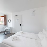 Bright double room with two beds, a desk and chair. A window with curtain and a wall mirror are visible., © Hotel Olgaeck Bright double room with two beds, a desk and chair. A window with curtain and a wall mirror are visible., © Hotel Olgaeck