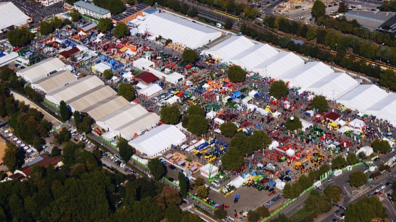 Luftaufnahme eines Messegel&auml;ndes mit vielen wei&szlig;en Zelten und bunten St&auml;nden, umgeben von B&auml;umen und Stra&szlig;en. Zahlreiche Besucher sind zu sehen., &copy; in.Stuttgart Veranstaltungsgesellschaft mbH & Co. KG