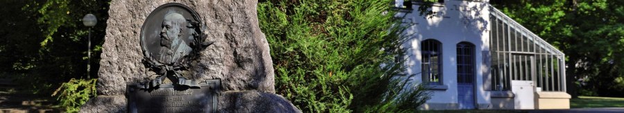 Memorial stone for Gottlieb Daimler in a green park, on the right a white building with glass windows., &copy; Stuttgart-Marketing GmbH Achim Mende
