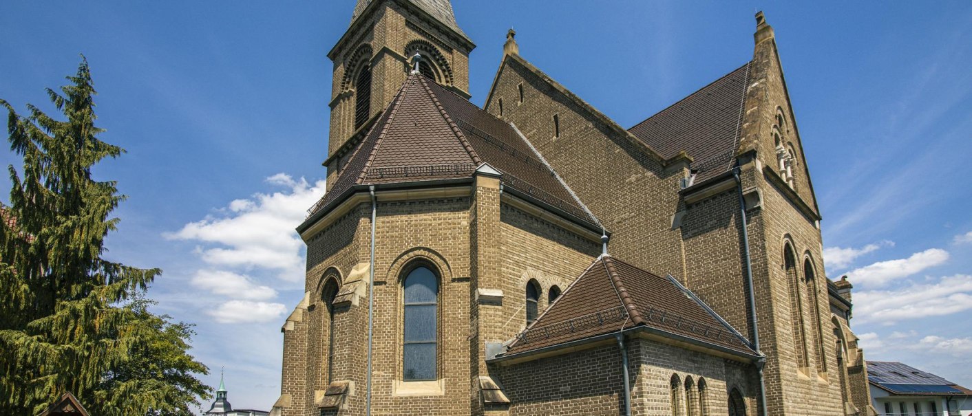 A church with brick walls and a tower, surrounded by trees, under a clear blue sky., © Stuttgart-Marketing GmbH, Sarah Schmid