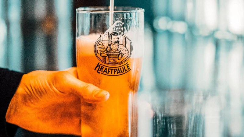 Ein Glas mit dem Logo von Kraftpaule wird mit Bier gef&uuml;llt. Im Hintergrund sind unscharfe Gl&auml;ser zu sehen., &copy; Kraftpaule, Stuttgart