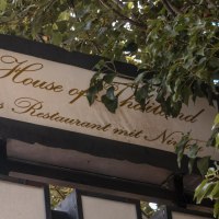 A sign with the inscription 'House of Thailand, the restaurant with class', surrounded by green leaves., &copy; SMG Stuttgart Marketing GmbH - Sarah Schmid
