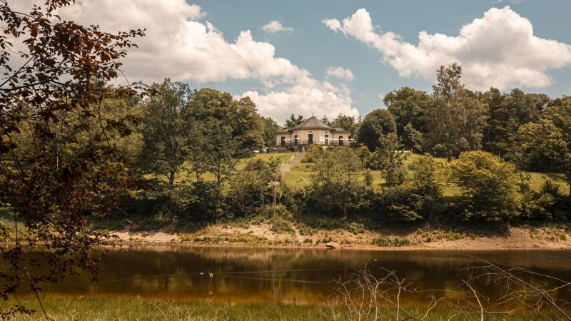Das B&auml;renschl&ouml;ssle thront auf einem gr&uuml;nen H&uuml;gel am B&auml;rensee, umgeben von &uuml;ppigen B&auml;umen und einem klaren Himmel mit wei&szlig;en Wolken., &copy; SMG, Sarah Schmid