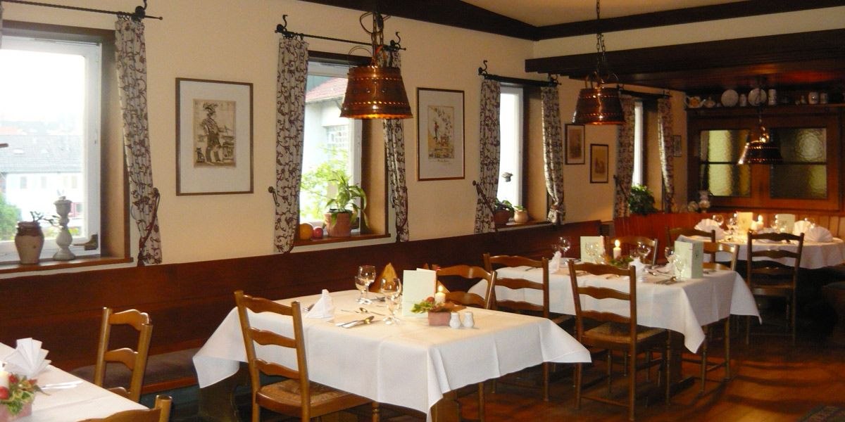 Gemütliches Restaurant mit Holzmöbeln, weißen Tischdecken und Kupferlampen. Fenster mit Vorhängen, dekorative Bilder und Pflanzen an den Wänden., © Hotel Gasthof Hirsch Gemütliches Restaurant mit Holzmöbeln, weißen Tischdecken und Kupferlampen. Fenster mit Vorhängen, dekorative Bilder und Pflanzen an den Wänden., © Hotel Gasthof Hirsch