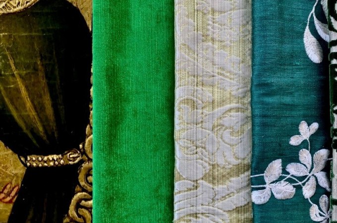 Grüne Stoffe in verschiedenen Texturen neben einem Gemälde mit goldenen Details und einem dunkelgrünen Gewand., © Landesmuseum Württemberg Grüne Stoffe in verschiedenen Texturen neben einem Gemälde mit goldenen Details und einem dunkelgrünen Gewand., © Landesmuseum Württemberg