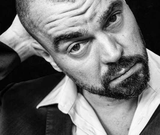 Black and white portrait of a man with a beard, looking thoughtfully and putting his hand behind his head., &copy; Rosenau Kultur e.V.