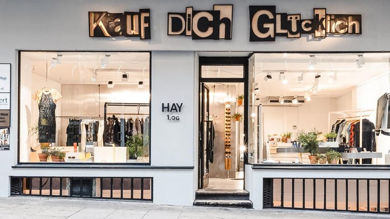 Schaufenster eines Modegesch&auml;fts namens 'Kauf Dich Gl&uuml;cklich' mit Kleidung und Pflanzen dekoriert., &copy; Kauf Dich Gl&uuml;cklich GmbH
