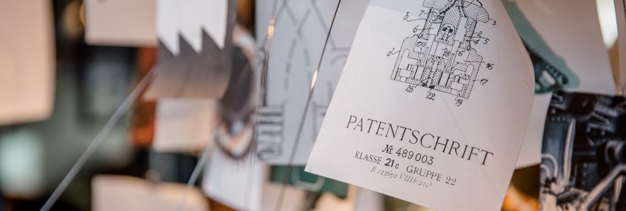 Nahaufnahme einer Patentschrift mit Zeichnung, umgeben von weiteren Papieren und Zeichnungen., © TOMAS Nahaufnahme einer Patentschrift mit Zeichnung, umgeben von weiteren Papieren und Zeichnungen., © TOMAS