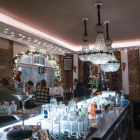 Festively decorated bar with chandeliers, guests at the bar and Christmas decorations. Glasses and bottles on the bar., © SMG Stuttgart Marketing GmbH - Sarah Schmid Festively decorated bar with chandeliers, guests at the bar and Christmas decorations. Glasses and bottles on the bar., © SMG Stuttgart Marketing GmbH - Sarah Schmid