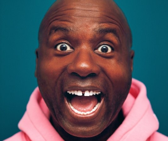 Ein Mann in einem rosa Hoodie schaut überrascht mit weit geöffnetem Mund und Augen in die Kamera, vor einem blauen Hintergrund., © Rosenau Kultur e.V. Ein Mann in einem rosa Hoodie schaut überrascht mit weit geöffnetem Mund und Augen in die Kamera, vor einem blauen Hintergrund., © Rosenau Kultur e.V.