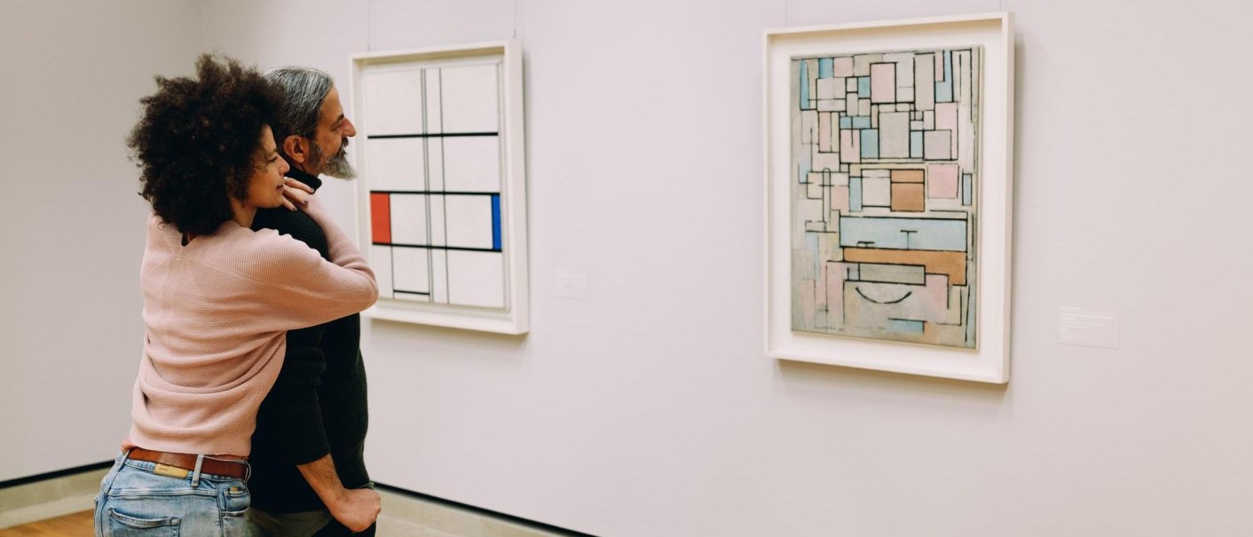 Ein Paar betrachtet zwei abstrakte Gemälde in einer Kunstgalerie. Die Gemälde zeigen geometrische Formen und Linien in verschiedenen Farben., © Stuttgart-Marketing GmbH, Alwin Maigler