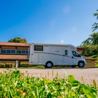 Wohnmobil auf einem Parkplatz vor einem Geb&auml;ude mit rotem Dach, umgeben von B&auml;umen und gr&uuml;nem Gras., &copy; Stuttgart-Marketing GmbH, Thomas Niederm&uuml;ller