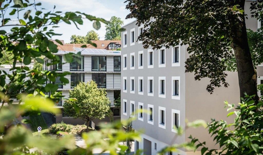 Two modern hotel buildings, surrounded by trees and green spaces, on a sunny day., &copy; a2 HOTELS am Quadrium
