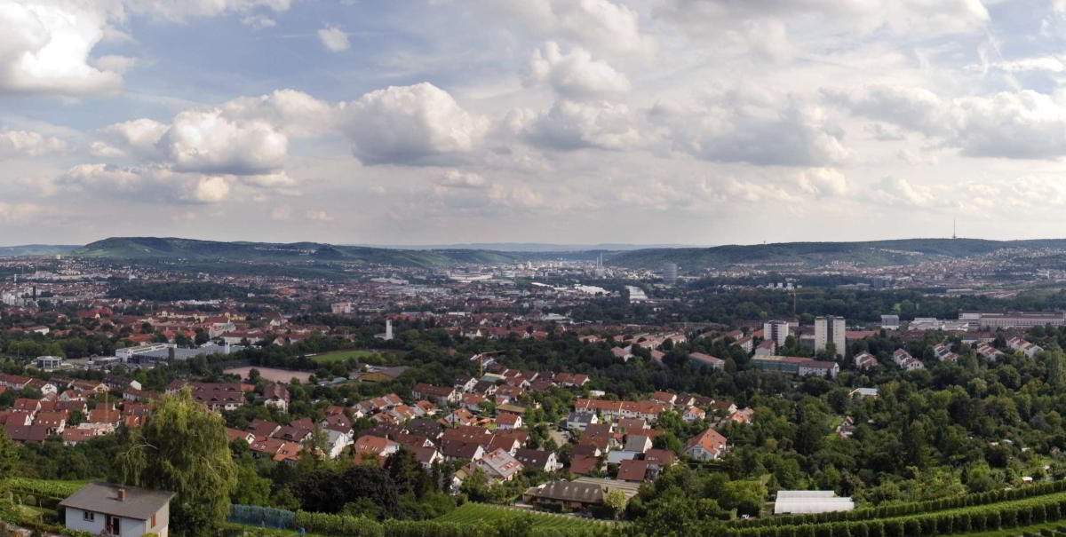 Panoramablick vom Burgholzhof auf Stuttgart mit Häusern, Weinbergen und bewölktem Himmel., © pjt56