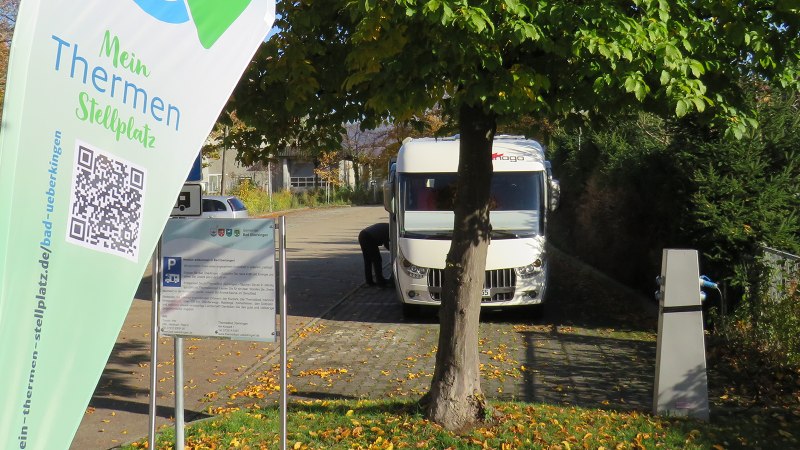 Wohnmobilstellplatz in Bad Überkingen mit einem geparkten Wohnmobil, Bäumen und einem Schild mit QR-Code und Informationen., © Archiv Gemeinde Bad Überkingen