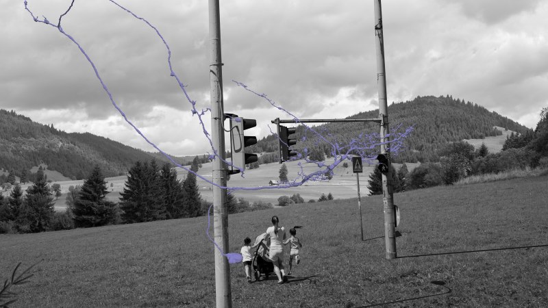 Schwarz-weißes Bild einer Landschaft mit Ampeln und lila Linien. Eine Person mit Kindern und Kinderwagen im Vordergrund, Hügel im Hintergrund., © balazs csizik Schwarz-weißes Bild einer Landschaft mit Ampeln und lila Linien. Eine Person mit Kindern und Kinderwagen im Vordergrund, Hügel im Hintergrund., © balazs csizik