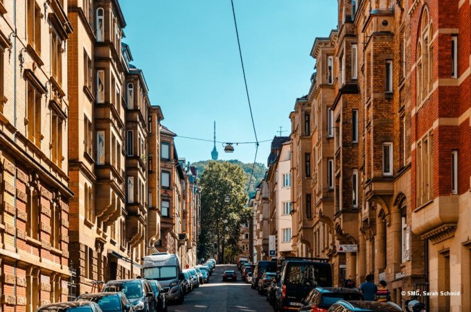 Eine belebte Straße in Stuttgart mit historischen Gebäuden und geparkten Autos. Im Hintergrund ist der Fernsehturm sichtbar., © Stuttgart Marketing GmbH