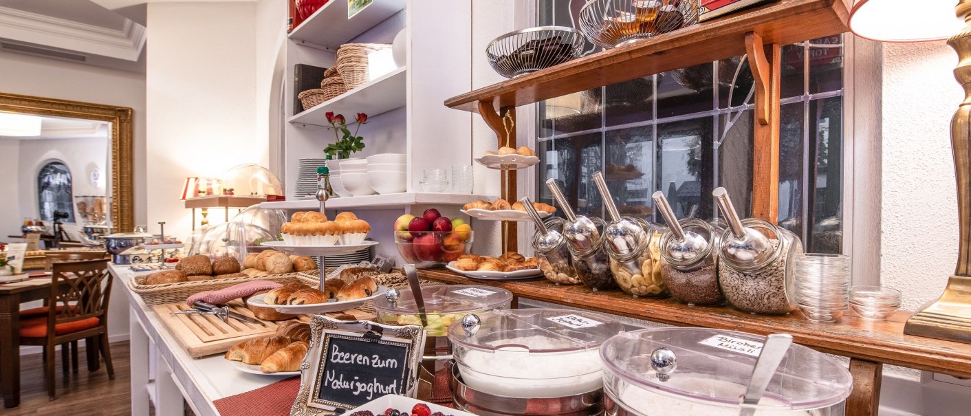 Ein reichhaltiges Frühstücksbuffet mit Brötchen, Croissants, Joghurt, Beeren und Müsli in einem stilvollen Raum., © Hotel Weinstadt Ein reichhaltiges Frühstücksbuffet mit Brötchen, Croissants, Joghurt, Beeren und Müsli in einem stilvollen Raum., © Hotel Weinstadt