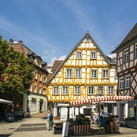Half-timbered houses in the old town of Backnang, surrounded by market stalls and passers-by in sunny weather., © Stuttgart-Marketing GmbH, Sarah Schmid