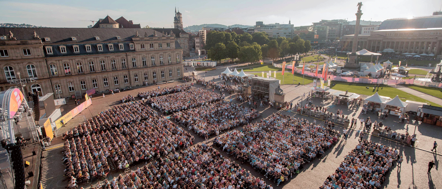 Luftaufnahme des SWR Sommerfestivals auf dem Schlossplatz Stuttgart. Viele Menschen sitzen vor einer B&uuml;hne, umgeben von historischen Geb&auml;uden und Gr&uuml;nfl&auml;chen., &copy; SWR, Markus Palmer