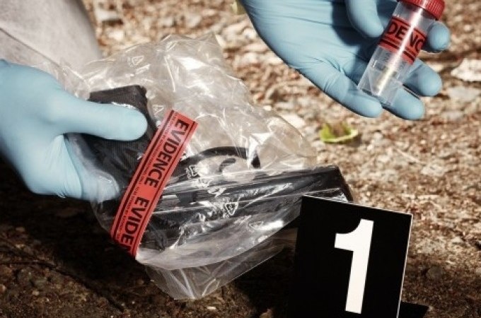 A crime scene with evidence: A weapon in a bag and a small evidence tube, numbered 1, are examined by a person wearing gloves., &copy; Cool-Tours StattReisen