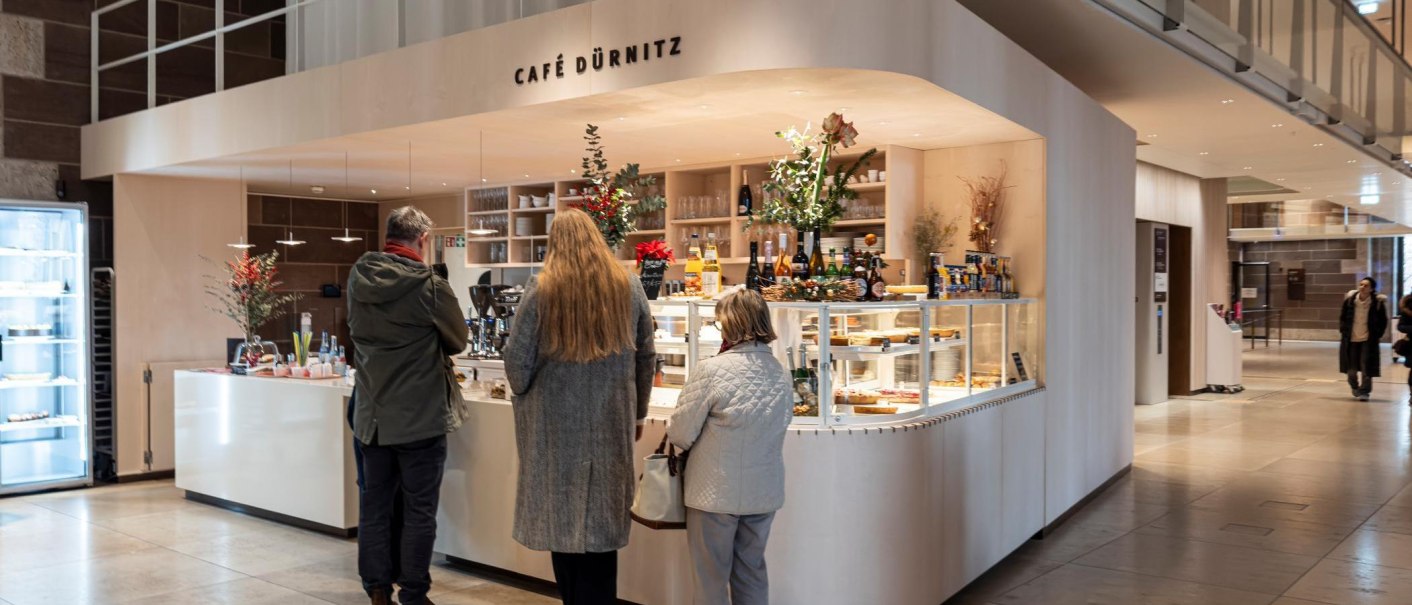 Bar with beverages, cakes and other snacks. Three people are waiting in line., &copy; SMG, Sarah Schmid