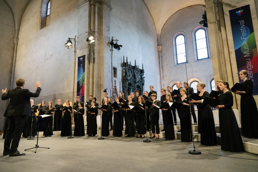 Der Kammerchor der Hochschule für Musik Frankfurt tritt in einer Kirche auf. Der Dirigent leitet den Chor, der in schwarzen Outfits singt., © Kammerchor der Hochschule für Musik Frankfurt Der Kammerchor der Hochschule für Musik Frankfurt tritt in einer Kirche auf. Der Dirigent leitet den Chor, der in schwarzen Outfits singt., © Kammerchor der Hochschule für Musik Frankfurt