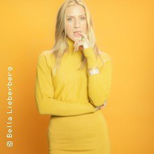 Eine Frau in einem gelben Kleid steht vor einem gelben Hintergrund und schaut nachdenklich in die Kamera., © links im Bild Eine Frau in einem gelben Kleid steht vor einem gelben Hintergrund und schaut nachdenklich in die Kamera., © links im Bild