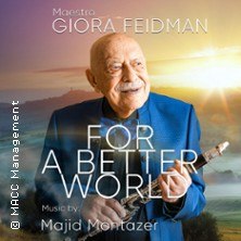 Ein &auml;lterer Mann in blauem Anzug h&auml;lt eine Klarinette. Der Hintergrund zeigt eine sonnige Landschaft. Text: Maestro Giora Feidman - For a Better World., &copy; links im Bild