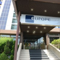 Eingang eines modernen Hotels mit dem Schild 'Europe Hotels Kongresshotel' &uuml;ber der Treppe. Links sind gr&uuml;ne B&uuml;sche zu sehen., &copy; Europe Hotels International